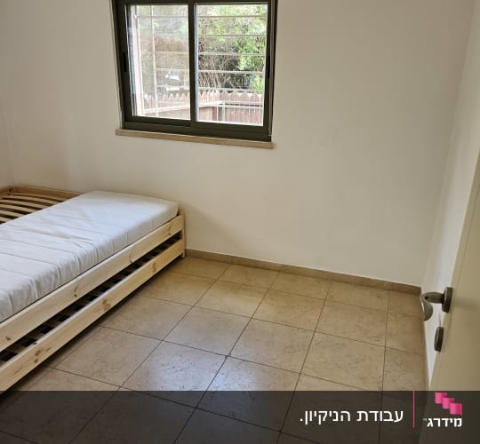 חדר ריק עם מיטה ורצפת אריחים